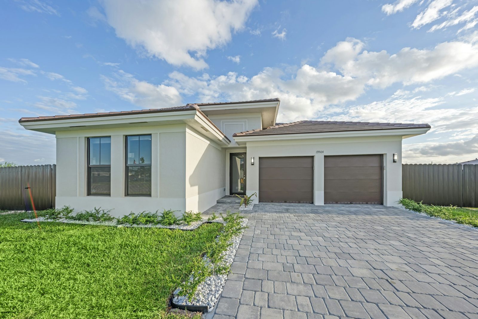 Modern single-story South Florida home with a paver driveway